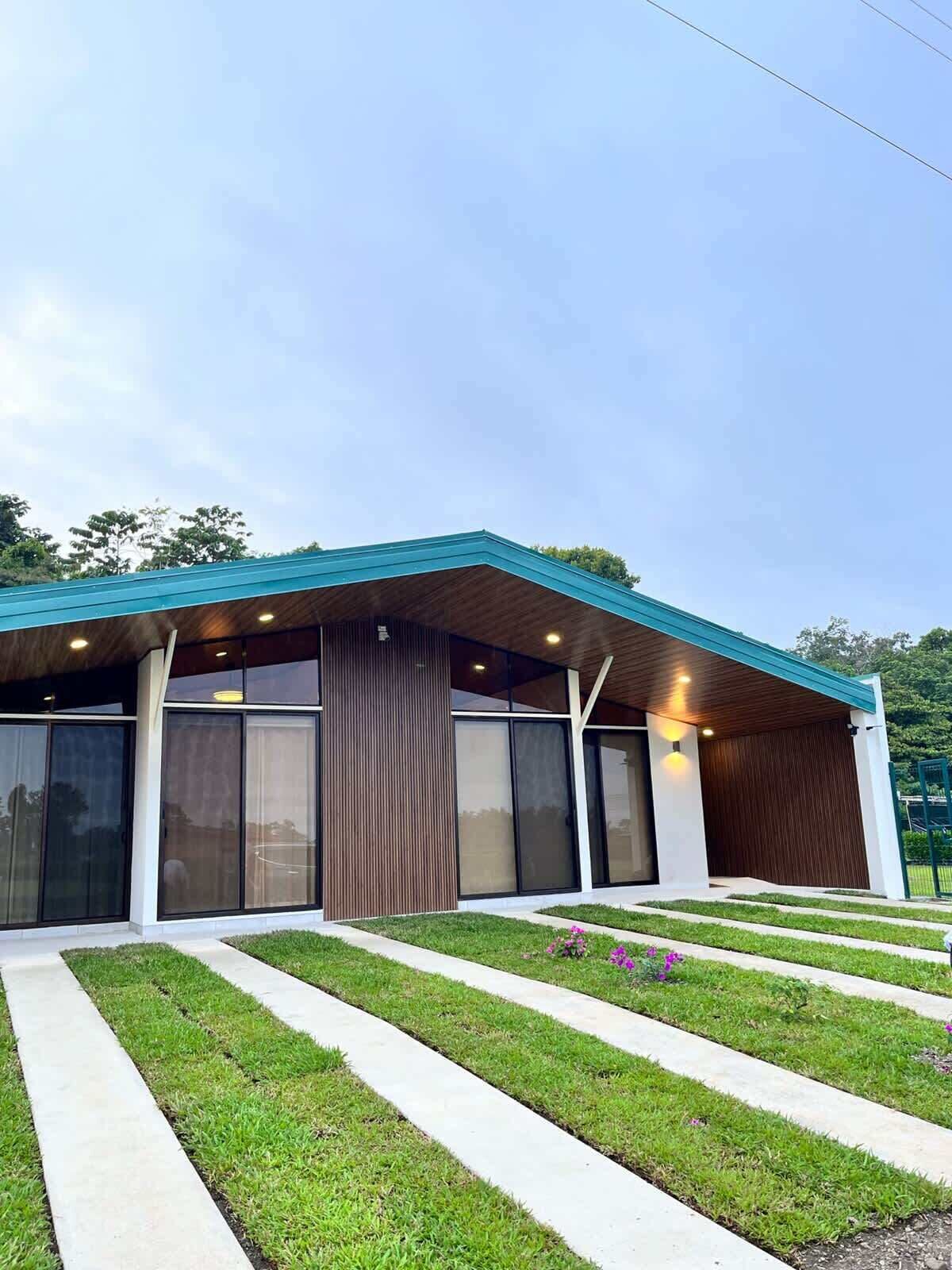 A modern building with a flat roof, large windows, and a covered entrance area.