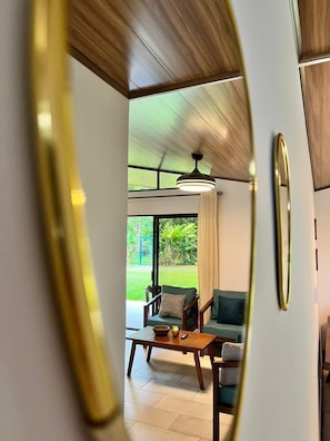 Ein modernes Interieur mit Holzboden, einem Essbereich mit Tisch und Stühlen und Blick auf Grünflächen.