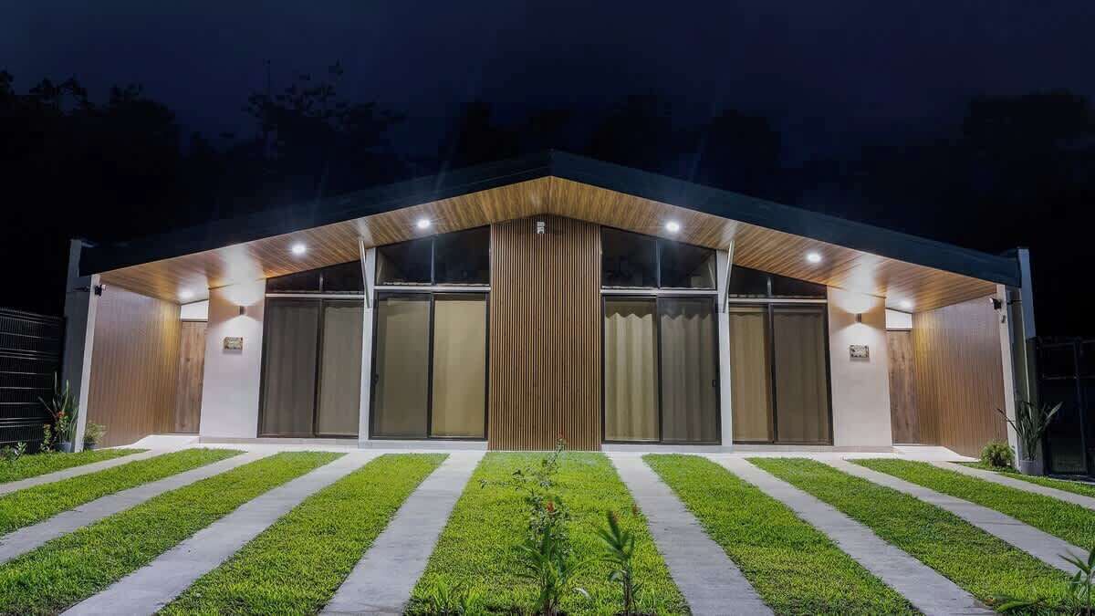 A modern building with a flat roof, large windows, and a central wooden column.