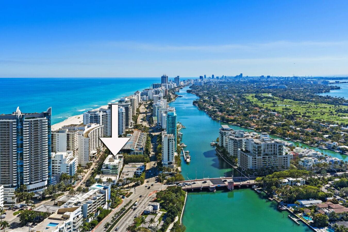 A coastal cityscape with high-rise buildings, a river, and a beach.