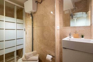 A modern bathroom with a glass shower enclosure, a white sink, and a mirror above it. - Apart. 3 bedr. 8'. Fira Barcelona and 20' Bcn center (L'Hospitalet de Llobregat)