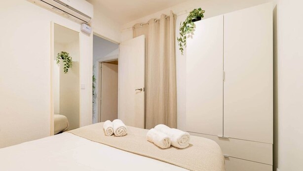 Ein Schlafzimmer mit Bett, Schrank und einer Badezimmertür.