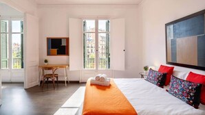 A bedroom with a bed, a desk, a chair, and a large window. - Apartment Luxe Gran Via 5 Bedrooms - 8 min Paseo Gracia (Barcelona)