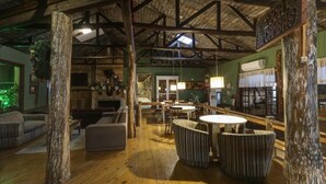 Un interior rústico con vigas de madera a la vista, una zona de bar y un espacio de estar.