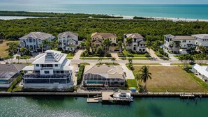 Una zona residencial costera con casas, un puerto deportivo y una playa.