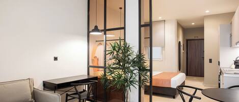 Un apartamento moderno con comedor, sala de estar, cocina y una puerta corredera que da a un dormitorio.