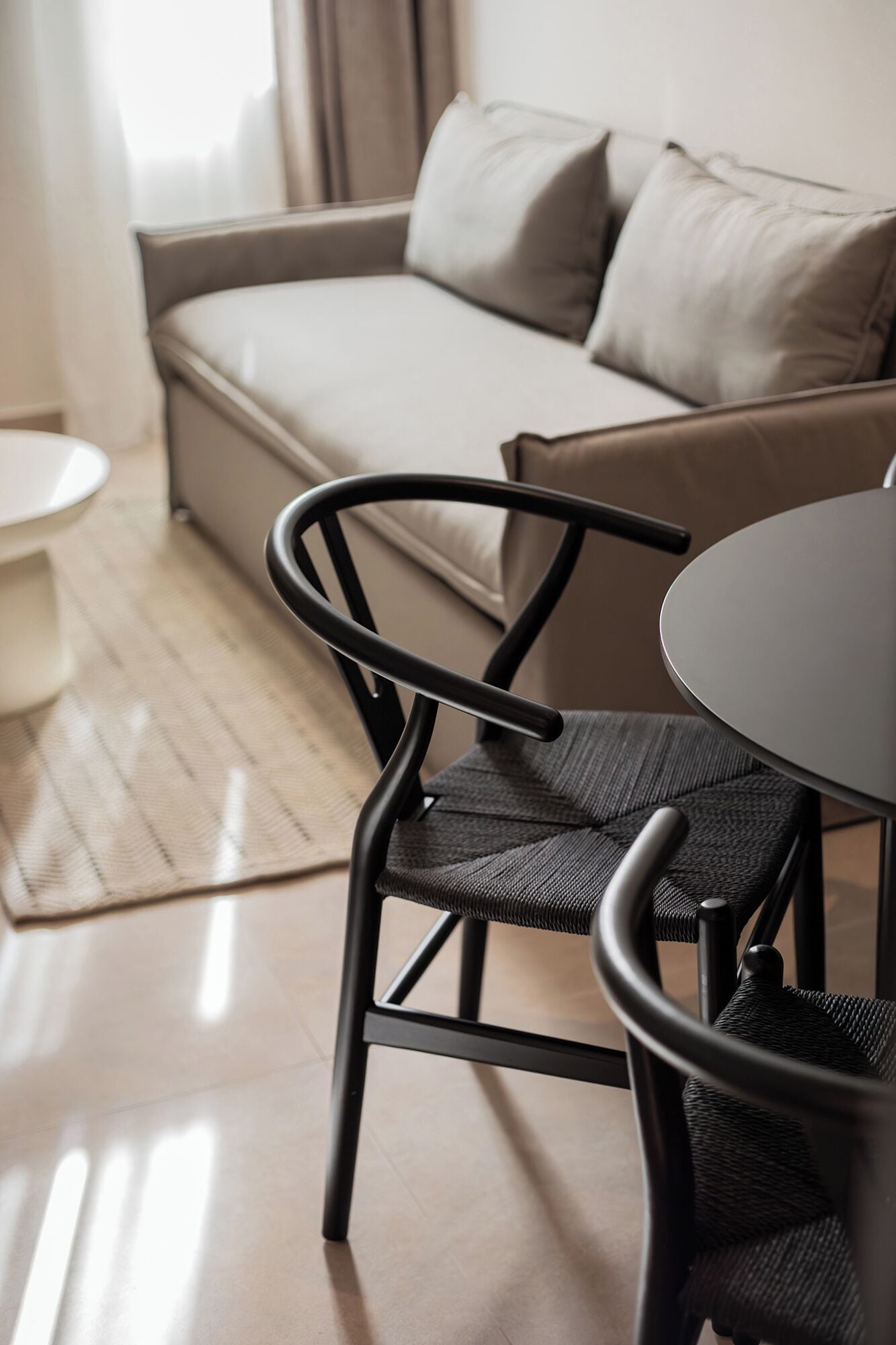 A modern living room with a sofa, a round table, and a chair.