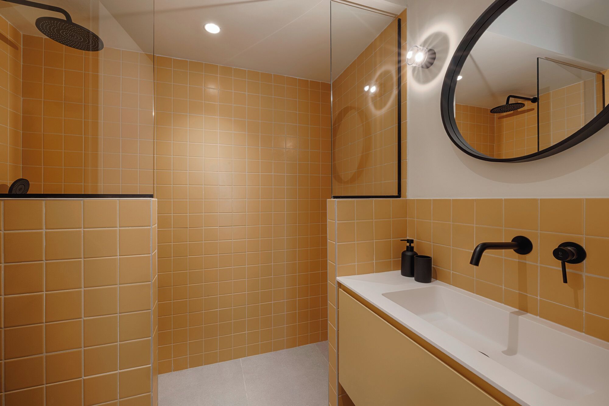 A bathroom with a shower, sink, and mirror.