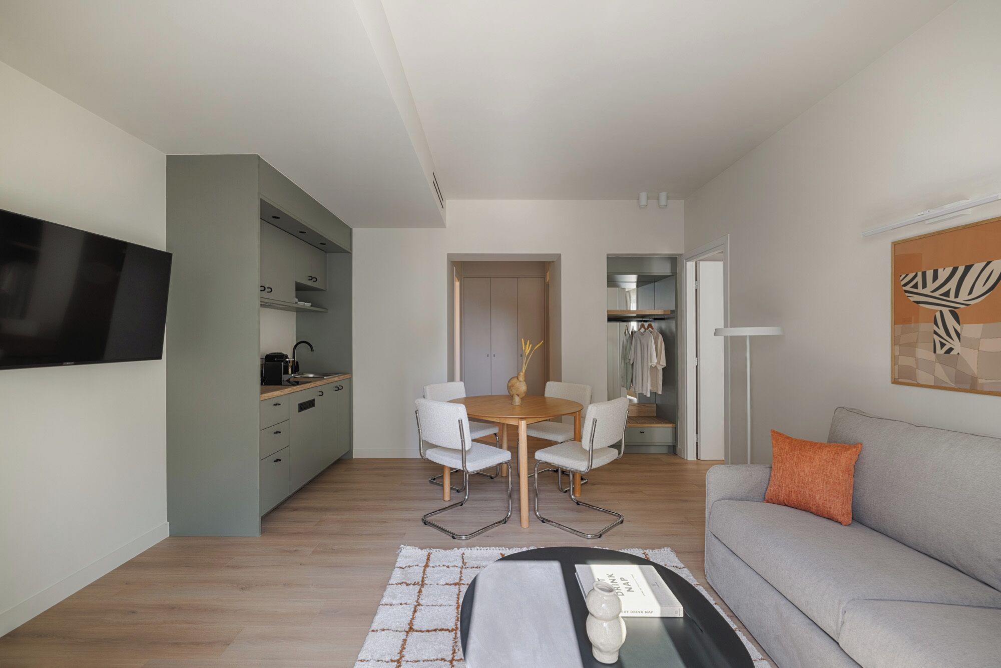 A modern apartment with a dining area, kitchenette, and living room.