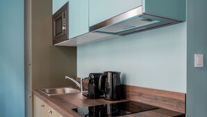 A modern kitchen with a built-in microwave, coffee maker, and a sleek stainless steel sink. - Didot by Zoia Living (Athina)