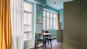 A room with a dining area, a bed, and a wardrobe.