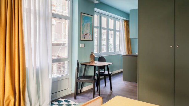 A room with a dining table, chairs, a cabinet, and a window with curtains. - Didot by Zoia Living (Athina)