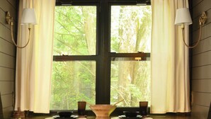 A wooden desk with two stools, a window with curtains, and a lamp on each side. - Romantic AFrame| Firepit| Grill | Projector | Pets (Pocono Pines)