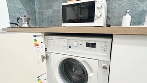 Una cucina funzionale con forno a microonde e lavatrice.