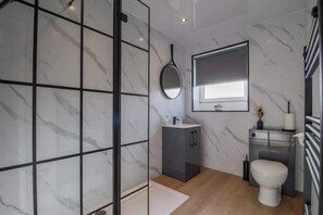 Un baño moderno con ducha, inodoro y tocador.
