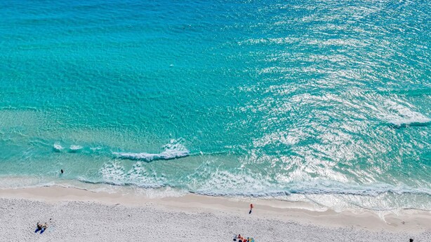 A beach with clear turquoise water, sandy shore, and people enjoying the beach. - Seapointe Serenity (Santa Rosa Beach)