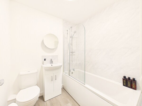 A modern bathroom with a toilet, sink, and shower.