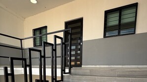 Una escalera con baldosas grises oscuras y barandillas de metal negro que lleva a una plataforma.