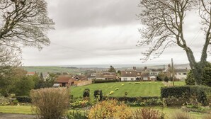 A residential area with houses, a grassy hill, and a distant view of the sea. - The Calf House (Saltburn-by-the-Sea)
