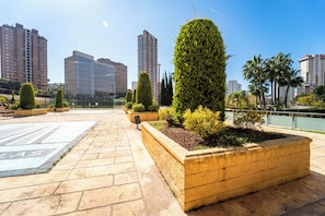 A rooftop garden with neatly trimmed hedges and a paved walkway. - Incredible views; Urbanization with Swimming Pool and Paddle Tennis (Benidorm)