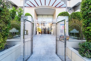 The entrance to a hotel with a modern design, featuring a glass facade and a sign reading "TORRE DOSCALAS". - Incredible views; Urbanization with Swimming Pool and Paddle Tennis (Benidorm)