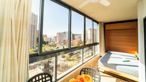 A bedroom with a large window, a ceiling fan, and a bed.