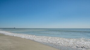 Uma praia com um cais que se estende para o mar.