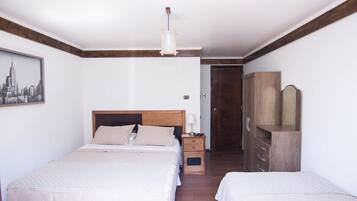 A bedroom with two beds, a wooden wardrobe, a nightstand, and a cityscape painting on the wall.