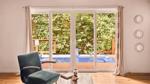 A room with a sliding glass door leading to a pool, a blue chair, and a small table.