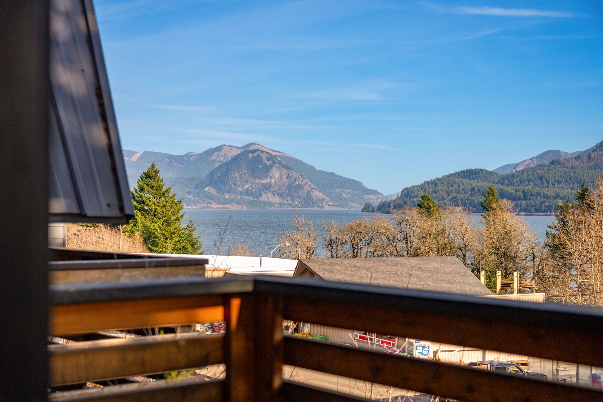 Une vue depuis un balcon donnant sur un lac, avec des montagnes en arrière-plan.