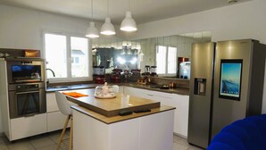 A modern kitchen with a central island, stainless steel appliances, and pendant lighting.