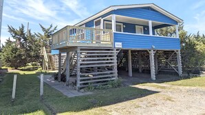 A two-story house with a balcony, wooden deck, and a number '26210' sign.