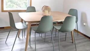 Un coin repas comprenant une table et des chaises, un ventilateur de plafond et une fenêtre avec des stores.