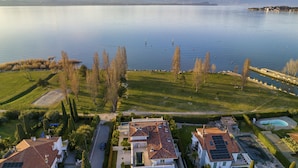A residential area with houses, a swimming pool, and a view of a lake. - Luxury Lake-Front Catullo A2 (Sirmione)