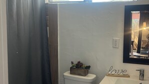 A small bathroom with a toilet, a sink, and a mirror. - Cozy Studio in Miramar (Miramar)