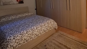 A bedroom with a bed, a wardrobe, and a patterned rug. - House of the stars (Lombardia)