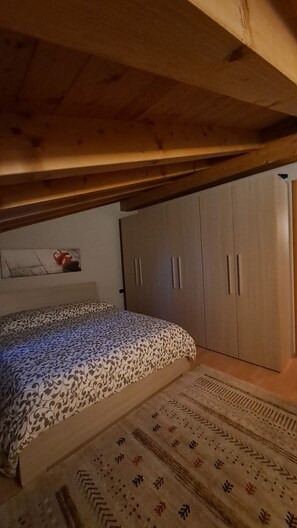 A bedroom with a bed, a wardrobe, and a patterned rug. - House of the stars (Lombardia)