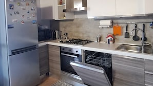 A modern kitchen with wooden beams, stainless steel appliances, and patterned tiles. - House of the stars (Lombardia)