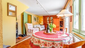 Une pièce chaleureuse avec une table ronde, une chaise, un canapé, une bibliothèque et une cheminée.