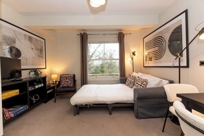 A modern bedroom with a bed, a desk, a chair, and a bookshelf. - Stunning 1 BR Surbiton with views, near station - Pass the Keys (Surbiton)