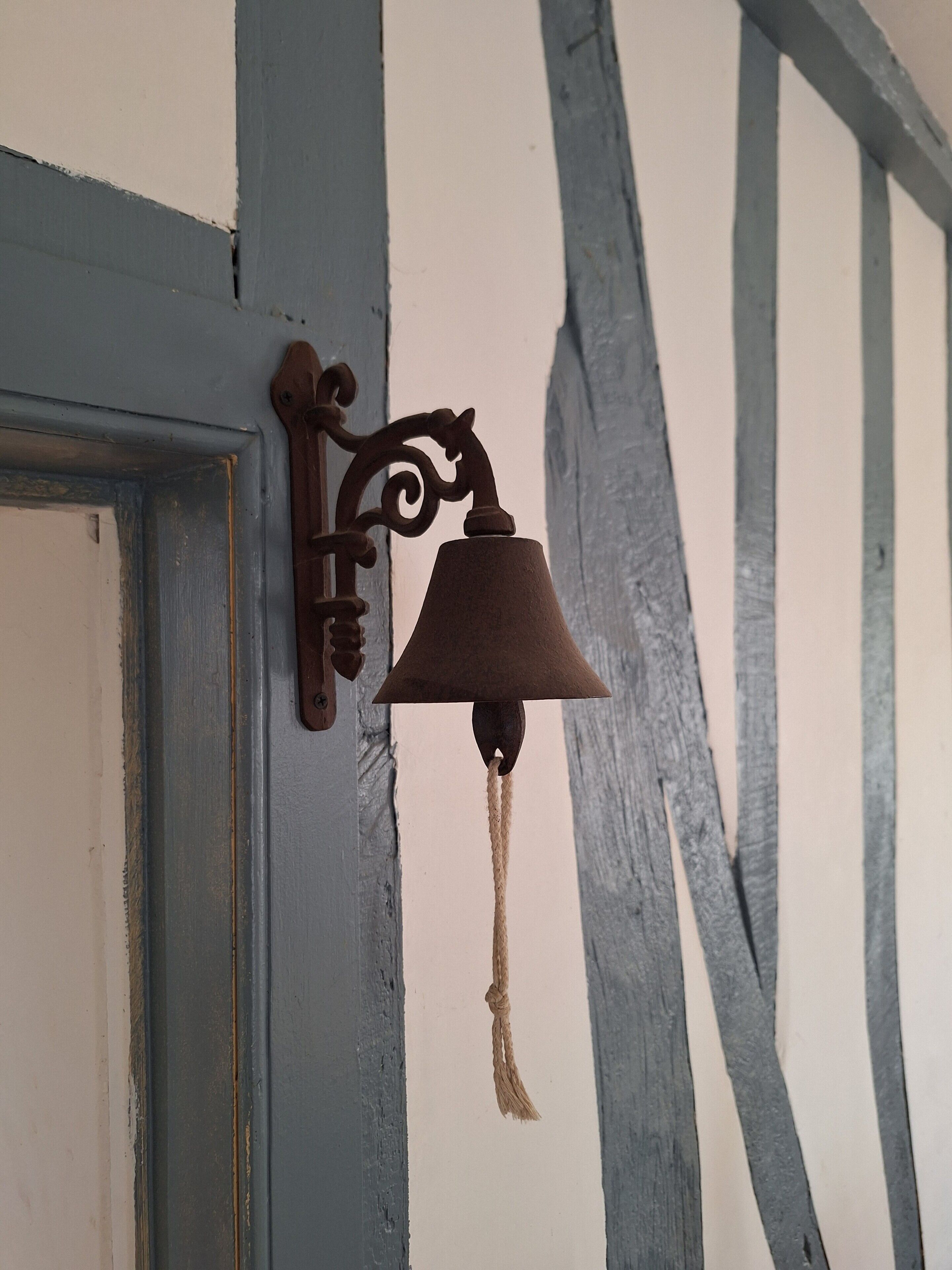 Un campanar fixat a la paret amb una corda.
