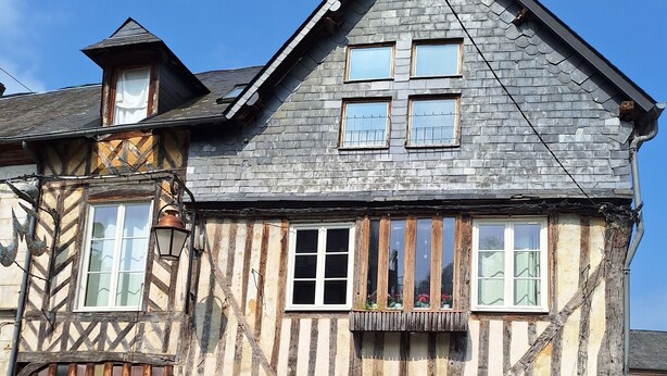 Il s’agit d’un bâtiment traditionnel à colombages, doté d’un toit à pignon très incliné, de nombreuses fenêtres et d’une porte en bois.