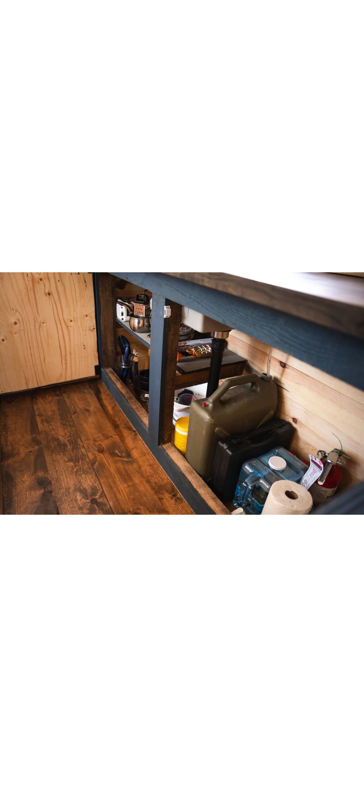 A narrow hallway with wooden flooring and a blue-painted ceiling.