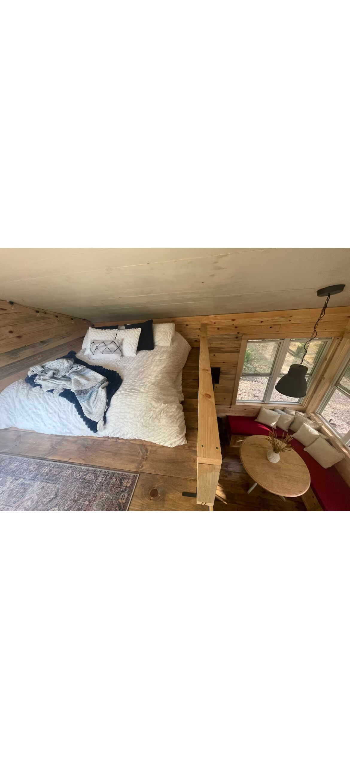 A cozy room with a bed, a small table, and a window.