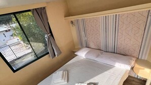A single bed with a headboard, a window with curtains, and a ceiling light. - Gargano Private Experience in the Heart of the Gargano - Nature & Sea (Villaggio Moresco Basso)
