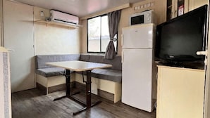 A compact kitchenette with a microwave, refrigerator, and a small TV. - Gargano Private Experience in the Heart of the Gargano - Nature & Sea (Villaggio Moresco Basso)