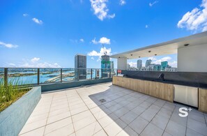 A rooftop terrace with a city view, a reception desk, and a pool. - Downtown Miami Luxury Condo - City Views (Miami)