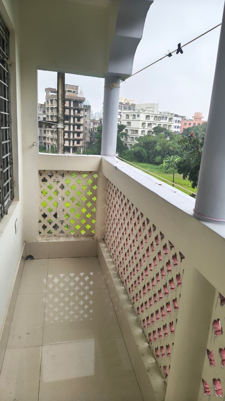 Un balcon avec vue sur les immeubles et la verdure.