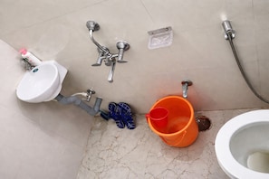 Un baño con lavamanos, ducha e inodoro.