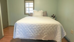 Un dormitorio con cama, ventana y planta en maceta.